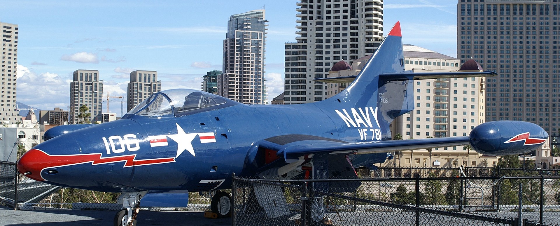 USS Midway Museum - Navy fighter on flight deck with San Diego in the background